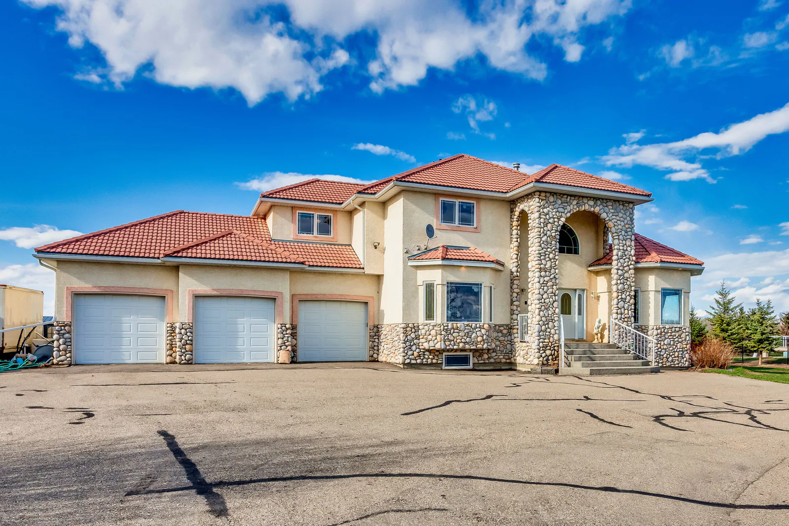 Front elevation with river-rock arch and cement tile roof