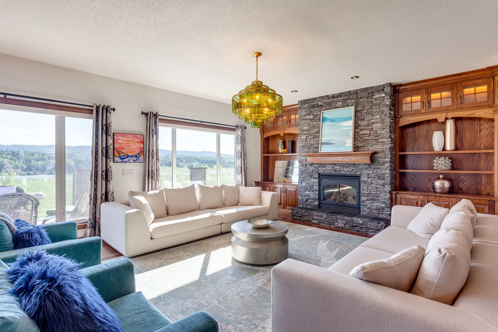 Great room with stone fireplace and valley windows