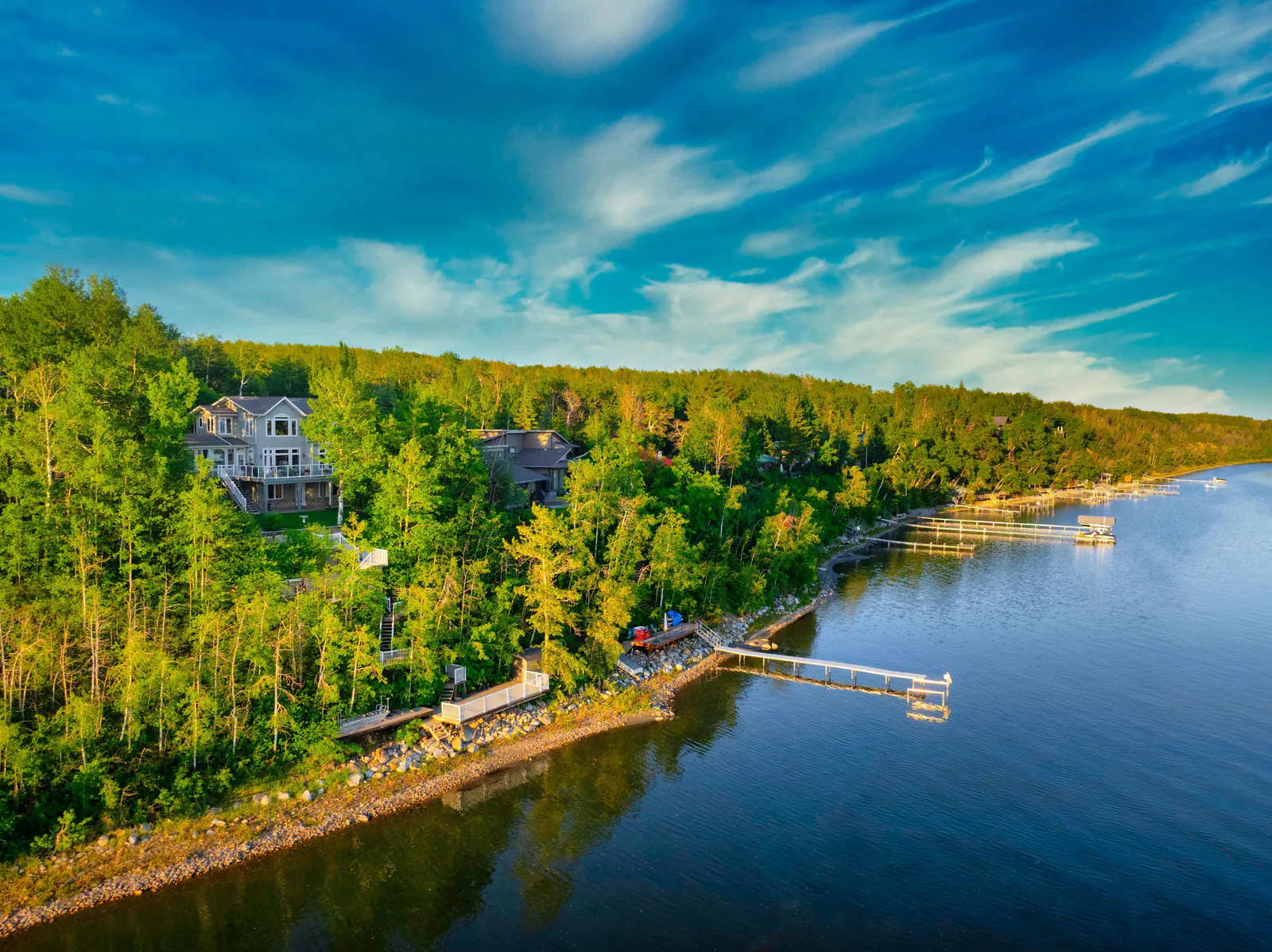 Aerial of the treed shoreline and lake frontage