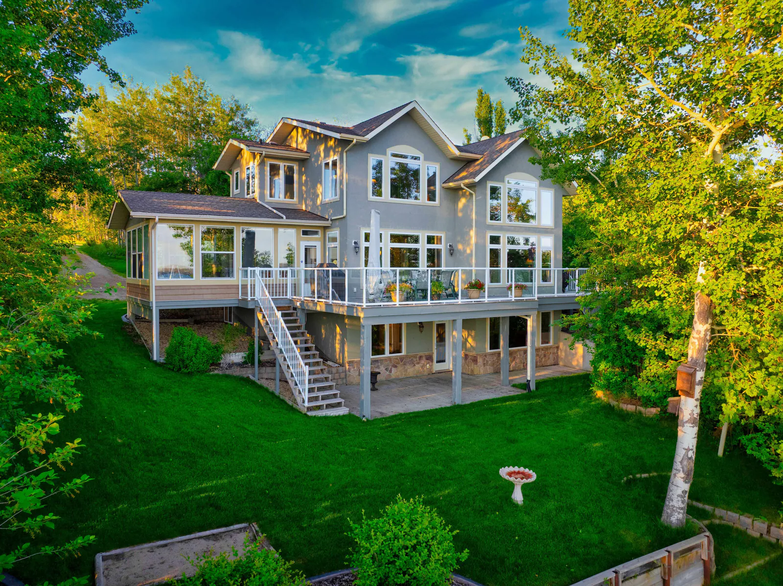 Rear elevation with tiered decks among mature trees