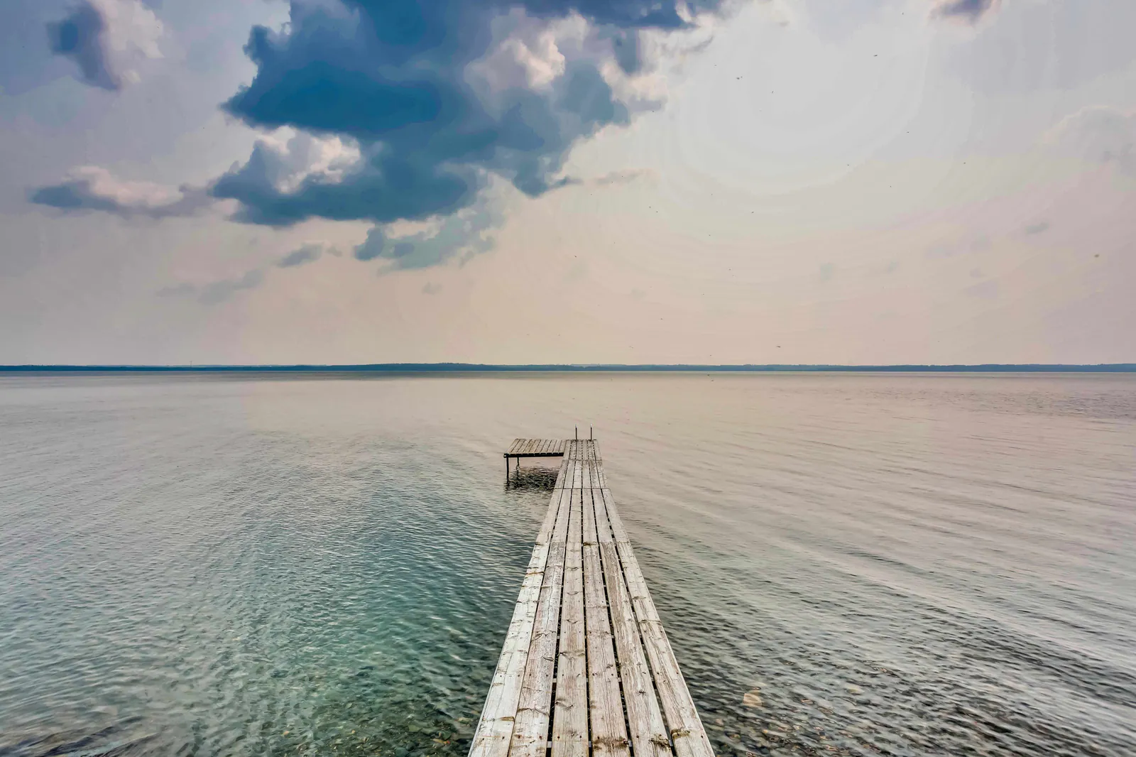 View down the dock over open water