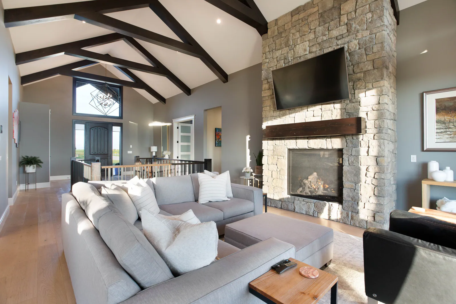 Great room with a vaulted timber-beam ceiling and stone fireplace