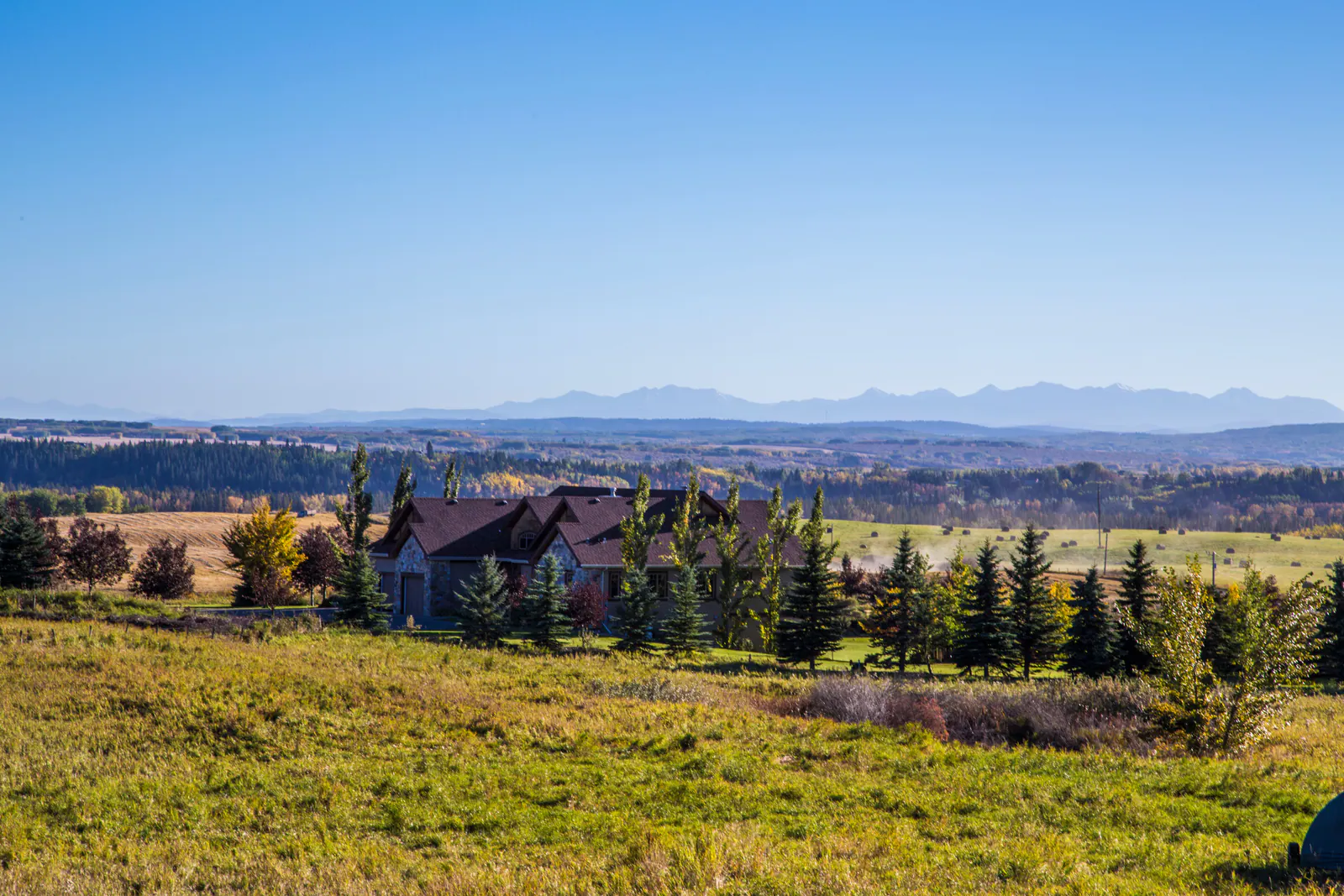 A Springbank acreage home among spruce and poplar with the Rockies on the horizon