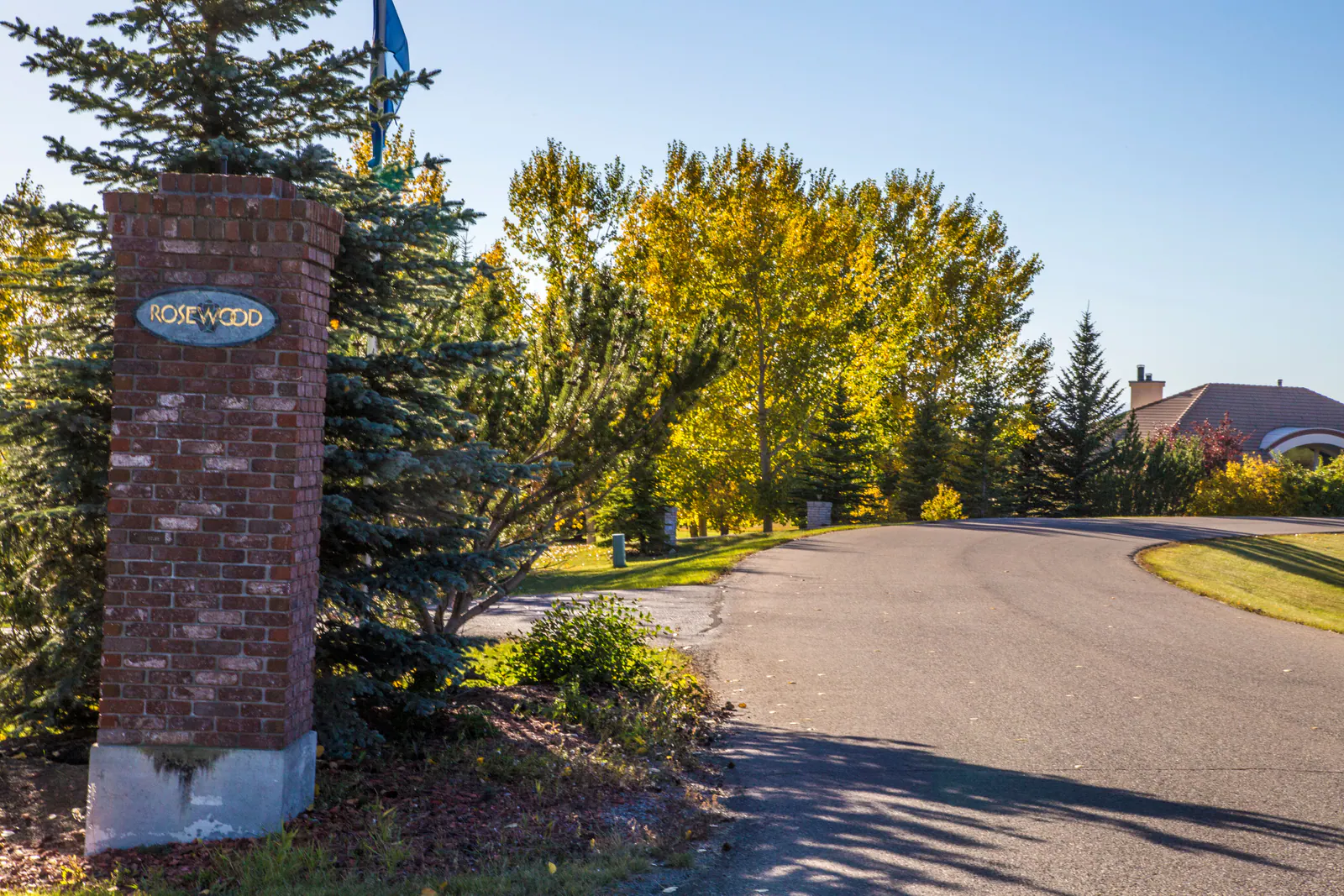 Brick entrance pillar at a treed Springbank country residential enclave